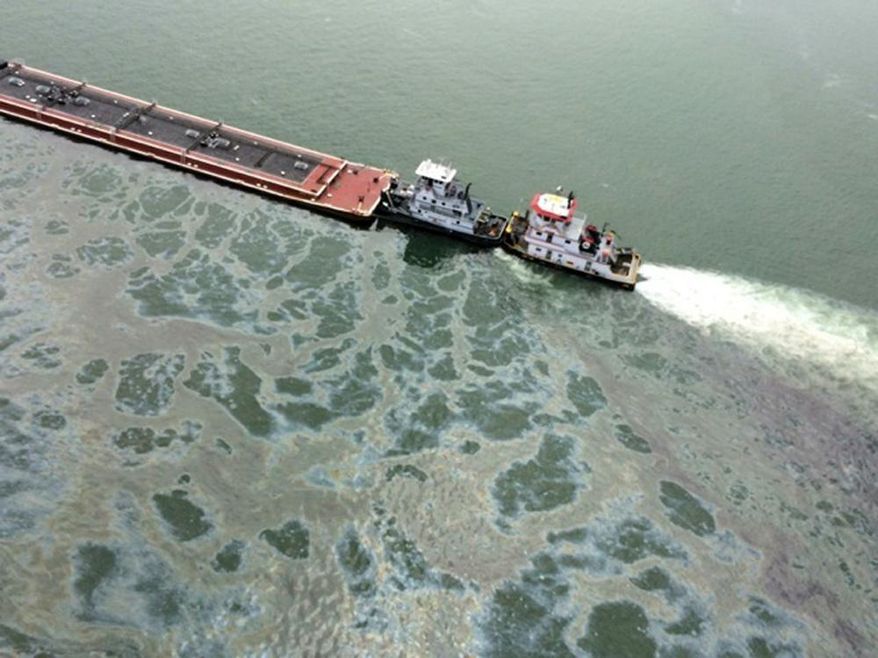 A barge loaded with marine fuel oil sits partially submerged in the Houston Ship Channel, March 22, 2014. The bulk carrier Summer Wind, reported a collision between the Summer Wind and the barge, containing 924,000 gallons of fuel oil. The barge collided with a ship in Galveston Bay on Saturday, leaking an unknown amount of the fuel into the popular bird habitat as the peak of the migratory shorebird season was approaching. (AP Photo/U.S. Coast Guard, PO3 Manda Emery)