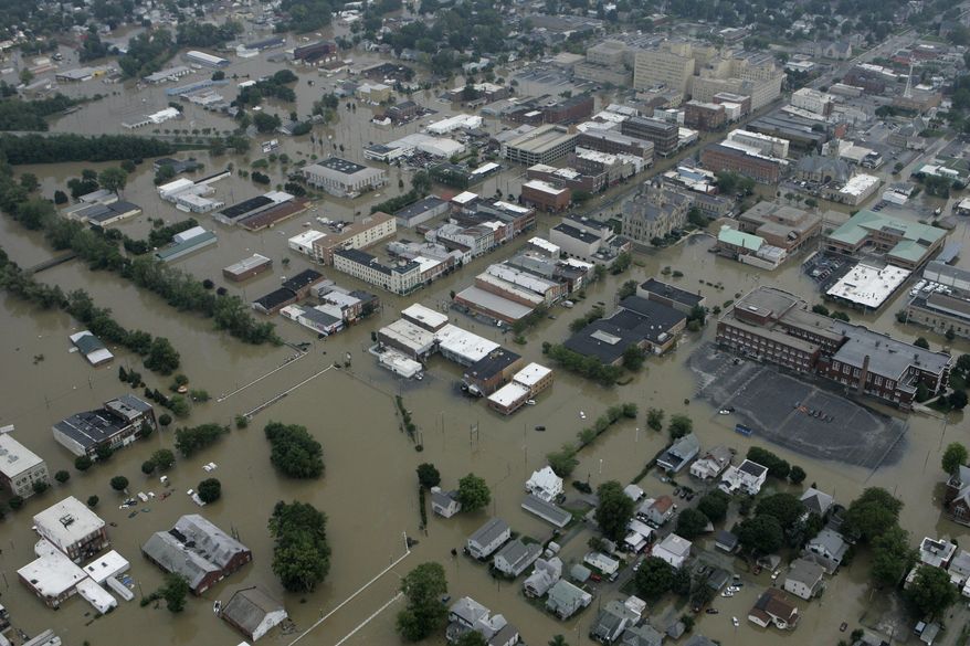 ADVANCE FOR USE MONDAY, MARCH 24, 2014 AT 3 A.M. AND THEREAFTER - FILE - This Aug. 22, 2007 aerial photo shows flood waters in downtown Findlay, Ohio. Many home and business owners across Ohio with national flood insurance are likely to be hit with rate increases in 2014. Around 20,000 property owners in the state are among the 1.1 million policyholders nationwide facing higher rates to rescue the debt-ridden National Flood Insurance Program, according to a review of federal data by The Associated Press. (AP Photo/Kiichiro Sato)