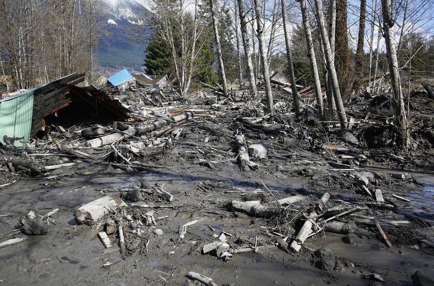 A house is seen destroyed in the mud on Highway 530 next to mile marker 37 on Sunday, March 23, 2014, the day after a giant landslide occurred near mile marker 37 near Oso, Washington. At least six homes have been washed away, with three people reported dead so far and at least eighteen missing. The nearby Stillaguamish River has been dammed up by 15-20 feet of debris as a result, creating more flooding concerns, as reported by KING 5 via the state hydrologist. (AP Photo/The Seattle Times, Lindsey Wasson, Pool)
