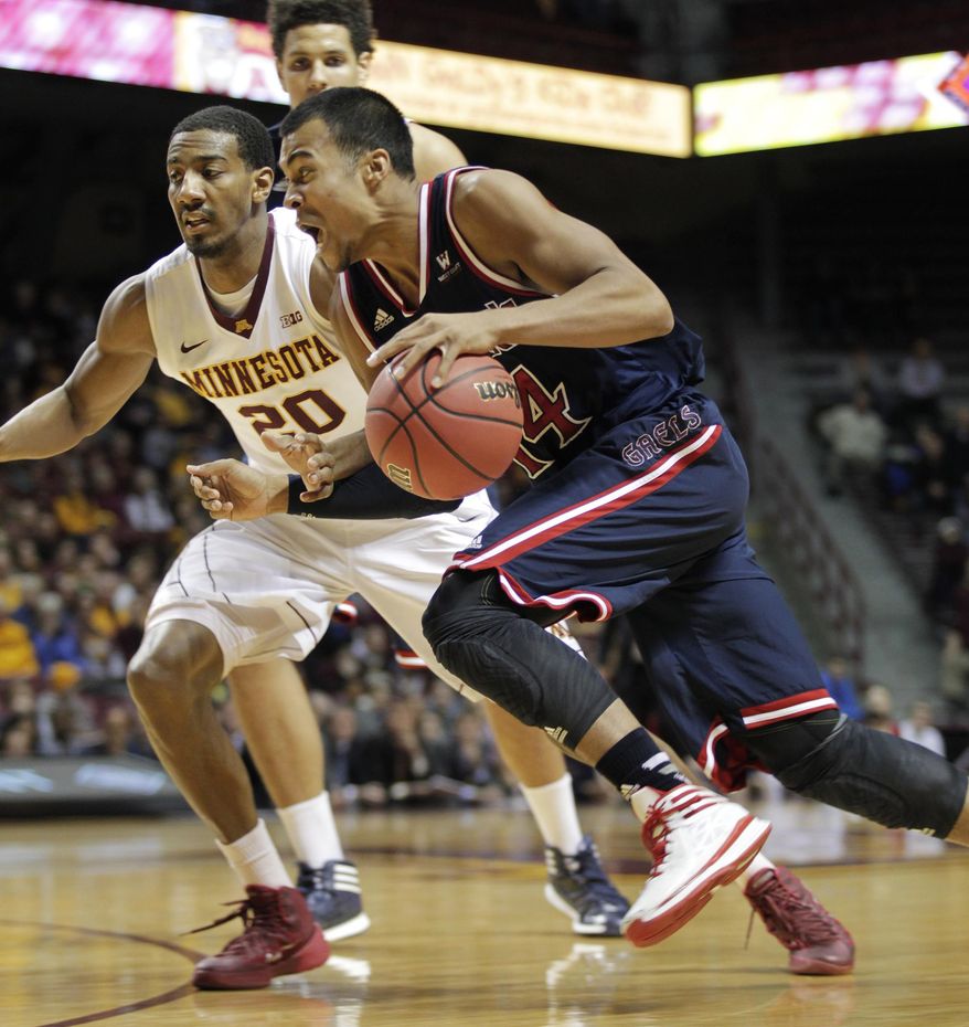 St. Mary's guard Stephen Holt (14) drives against Minnesota guard Austin Hollins (20) during the first half of an NIT tournament second-round game, Sunday, March 23, 2014, in Minneapolis. (AP Photo/Paul Battaglia)