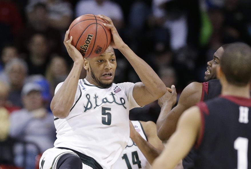 Michigan State's Adreian Payne pulls down a rebound against Harvard in the second half during the third round of the NCAA men's college basketball tournament in Spokane, Wash., Saturday, March 22, 2014. Michigan State won 80-73. (AP Photo/Elaine Thompson)