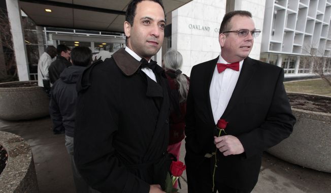 Nasir Khawaja, left, and Mark Sarver stand outside in line to apply for a marriage license at the Oakland County Clerks office in Pontiac, Mich., Saturday, March 22, 2014. A federal judge has struck down Michigan&#x27;s ban on gay marriage Friday the latest in a series of decisions overturning similar laws across the U.S. Some counties plan to issue marriage licenses to same-sex couples Saturday, less than 24 hours after a judge overturned Michigan&#x27;s ban on gay marriage. (AP Photo/Paul Sancya)