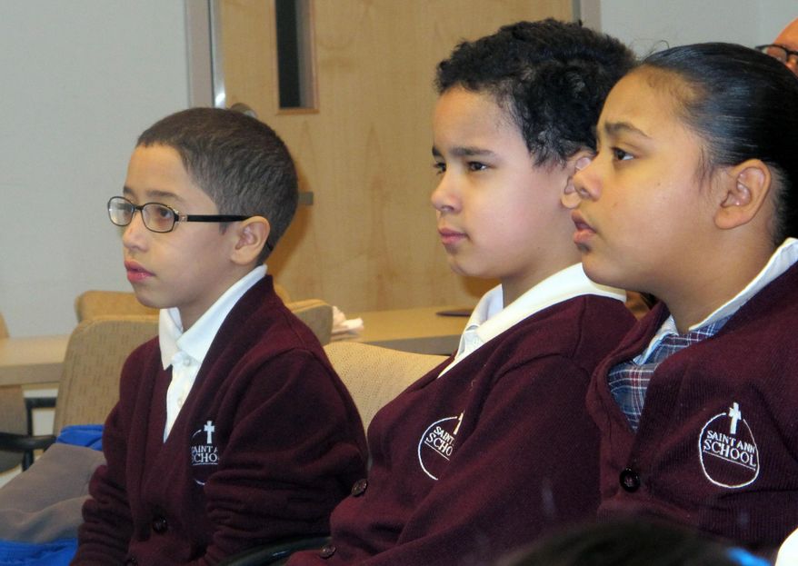 In this Feb. 25, 2014 photo, third-graders, from left, Jan Carlos Medina, Matthew Velez and Natalie Mieses take in a class that teaches them about stroke on Feb. 25, 2014, at Montefiore Hospital in the Bronx, N.Y. The hospital educates children to recognize stroke and get victims to a hospital quickly. (AP Photo/Jim Fitzgerald)