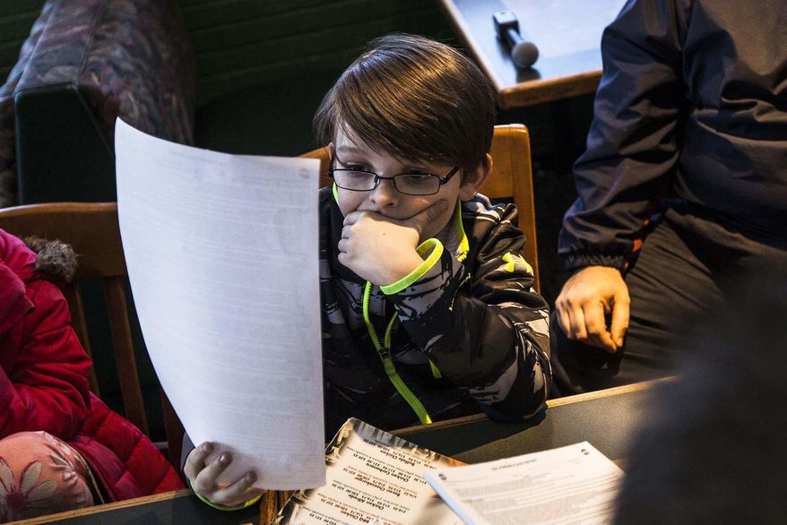 In this Tuesday, March 18, 2014 photo, Colin, 11, of Richland, Mich., looks over the contract he signed that was given to him by Kalamazoo Wings coach Nick Bootland. The team presented Colin with a one-day contract that will allow him to join the Wings for their home game Sunday. Colin has a condition similar to Asperger's syndrome that makes it difficult to relate to peers. (AP Photo/Kalamazoo Gazette-MLive Media Group, Chuck Miller) ALL LOCAL TV OUT; LOCAL TV INTERNET OUT