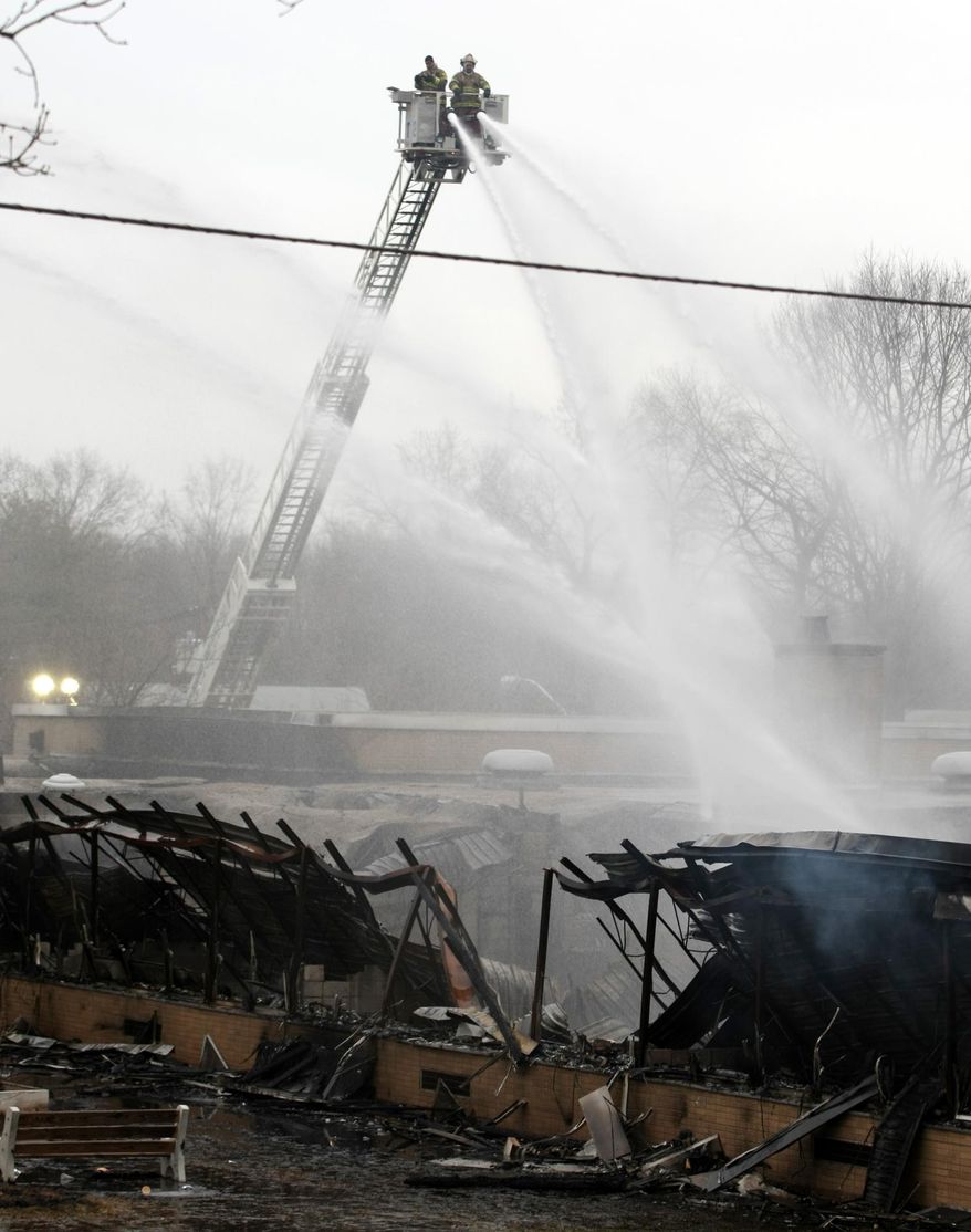 Firefighters spray the ruins at James Monroe School, following a fire at the school in Edison Township, N.J., Sunday, March 23, 2014. The fire began Saturday night, and district officials met Sunday afternoon to develop a plan for the affected children. (AP Photo/Home News Tribune, Jason Towlen) NEWARK OUT; NO SALES; NEWARK STAR LEDGER OUT