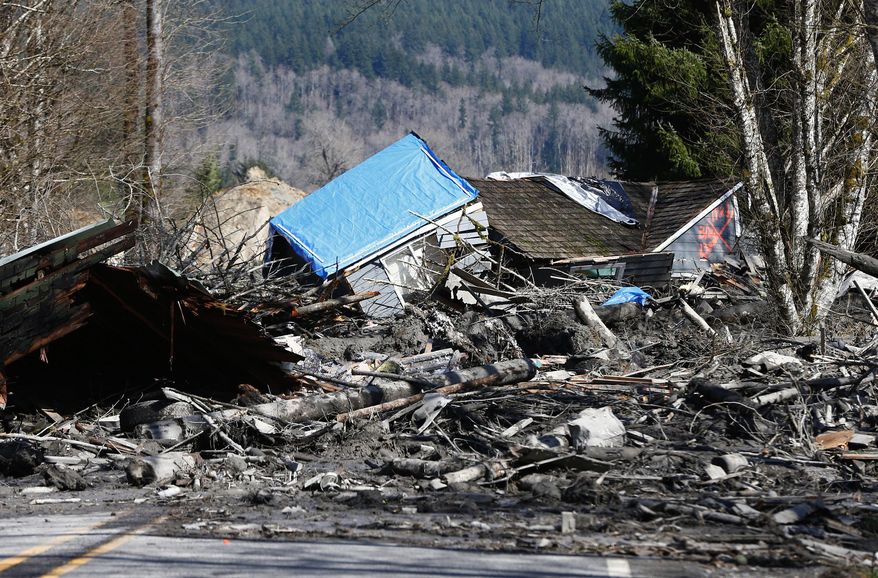 A house is seen destroyed in the mud on Highway 530 next to mile marker 37 on Sunday, March 23, 2014, the day after a giant landslide occurred near mile marker 37 near Oso, Washington. At least six homes have been washed away, with three people reported dead so far and at least eighteen missing. The nearby Stillaguamish River has been dammed up by 15-20 feet of debris as a result, creating more flooding concerns, as reported by KING 5 via the state hydrologist. (AP Photo/The Seattle Times, Lindsey Wasson, Pool)