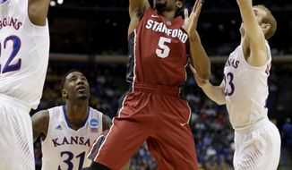 Stanford&#39;s Chasson Randle (5) gets between Kansas&#39;s Andrew Wiggins, left, Conner Frankamp (23) and k23=, right, to shoot during the first half of a third-round game at the NCAA college basketball tournament Sunday, March 23, 2014, in St. Louis. (AP Photo/Charlie Riedel)