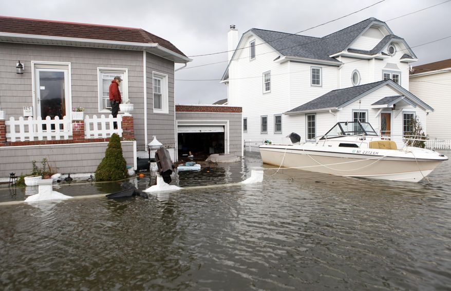 FILE - In this Oct. 30, 2012 file photo, a boat floats in the driveway of a home in the aftermath of Superstorm Sandy in Lindenhurst, N.Y. While President Barack Obama signed a law Friday, March 21, 2014 that will delay steep increases to flood insurance paid by many, nearly 60,000 policyholders in New York state are among the 1.1 million nationwide who will see their federally subsidized flood insurance premiums rise as part of changes to the National Flood Insurance Program, according to a review of federal data by The Associated Press. (AP Photo/Jason DeCrow, File)