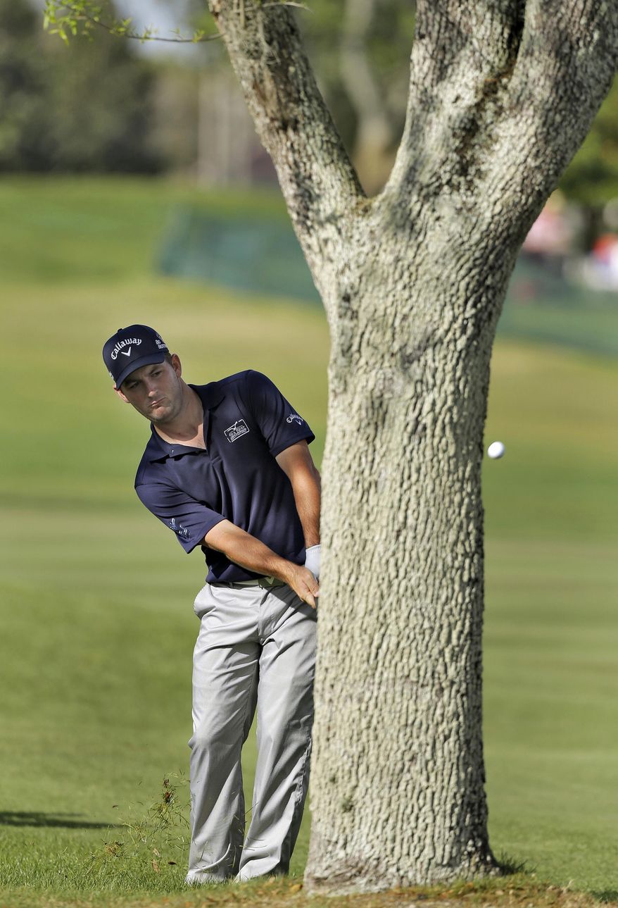 Matt Every hits from behind a tree on the 16th hole during the final round of the Arnold Palmer Invitational golf tournament at Bay Hill, Sunday, March 23, 2014, in Orlando, Fla. Every went onto win the tournament. (AP Photo/Chris O'Meara)