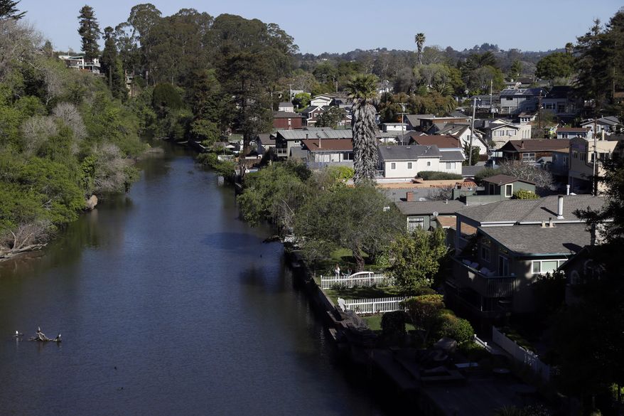 Soquel Creek runs along a residential district on Wednesday, March 19, 2014, in Capitola , Calif. The historic community of 10,000, locally known as the Jewel Box for it’s cute boutiques, galleries, coffee shops and ocean front dining, sits smack in the middle of two different floodplains. Soquel Creek is more of a river than a creek in wet winters when it storms through downtown Capitola, a rage of muddy water, fallen trees and debris after a 16 mile run through the Santa Cruz Mountains to the Monterey Bay. (AP Photo/Marcio Jose Sanchez)