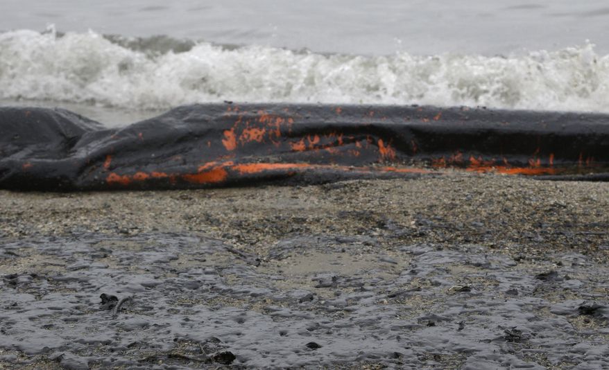 A boom and the sand along East Beach are covered in oil Monday, March 24, 2014, in Galveston, Texas. Thousands of gallons of tar-like oil spilled into the major U.S. shipping channel after a barge ran into a ship Saturday. (AP Photo/Pat Sullivan)