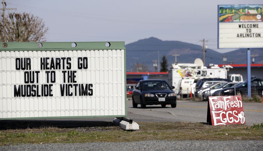 A sign outside a coffee shop references a deadly mudslide that happened two days earlier, Monday, March 24, 2014, in Arlington, Wash. Officials said that there are currently 108 names of people who have been reported missing or are unaccounted for from the Saturday morning slide, but cautioned the figure would likely decline dramatically. Eight people are so far confirmed dead from the one-square mile slide that destroyed about 30 homes and critically injured several people. (AP Photo/Elaine Thompson)