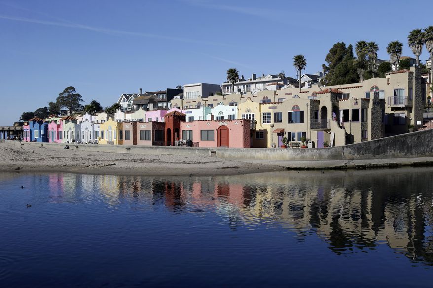 A row of condominiums is reflected on the water of Soquel Creek on Wednesday, March 19, 2014, in Capitola , Calif. The historic community of 10,000, locally known as the Jewel Box for it’s cute boutiques, galleries, coffee shops and ocean front dining, sits smack in the middle of two different floodplains. Soquel Creek is more of a river than a creek in wet winters when it storms through downtown Capitola, a rage of muddy water, fallen trees and debris after a 16 mile run through the Santa Cruz Mountains to the Monterey Bay. (AP Photo/Marcio Jose Sanchez)