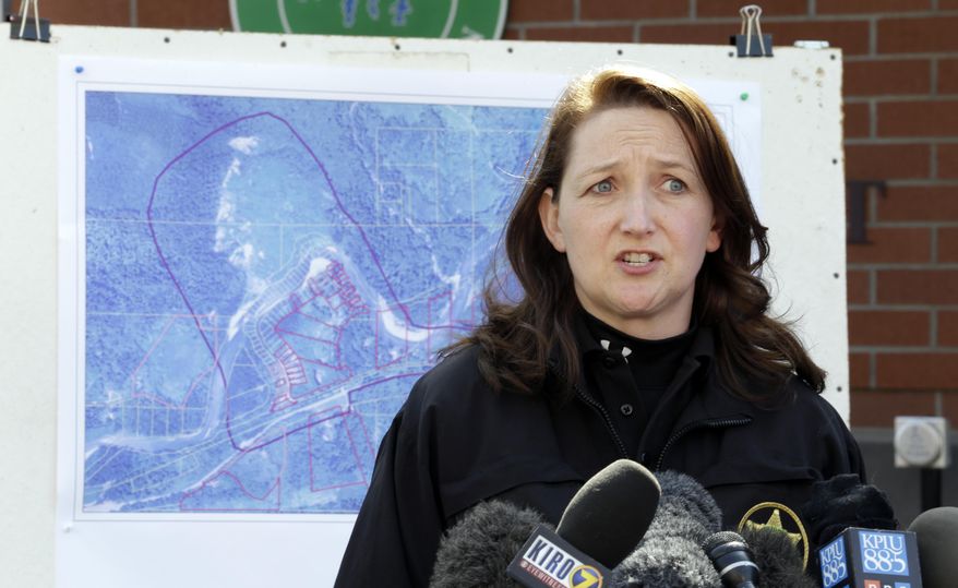 Snohomish County Sheriff's Dept. public information officer Shari Ireton speaks briefly to media members about a deadly mudslide that happened two days earlier, Monday, March 24, 2014, in Arlington, Wash. A map of the slide area is behind her. Officials said that there are currently 108 names of people who have been reported missing or are unaccounted for from the Saturday morning slide, but cautioned the figure would likely decline dramatically. Eight people are so far confirmed dead from the one-square mile slide that destroyed about 30 homes and critically injured several people. (AP Photo/Elaine Thompson)