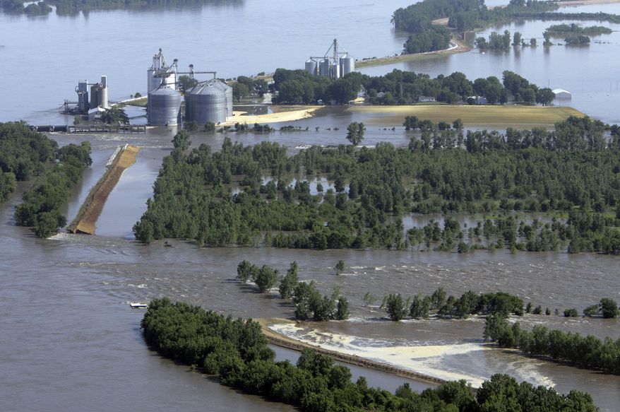 FILE - In this June 19, 2008 file photo, floodwaters from the Mississippi River surround a grain elevator in Meyer, Ill. after a levee failed, flooding the farming community. Policyholders who have long enjoyed subsidized rates under the debt-ridden National Flood Insurance Program will see premiums rise steadily in the coming years, despite a rate-relief law signed Friday, March 21, 2014 by President Barack Obama that will soften the blow for those who were hit hardest. The fallout appears profound in Illinois, partly because of the state's proximity to the Mississippi, Ohio and Illinois rivers and their tributaries. (AP Photo/M. Spencer Green, File)