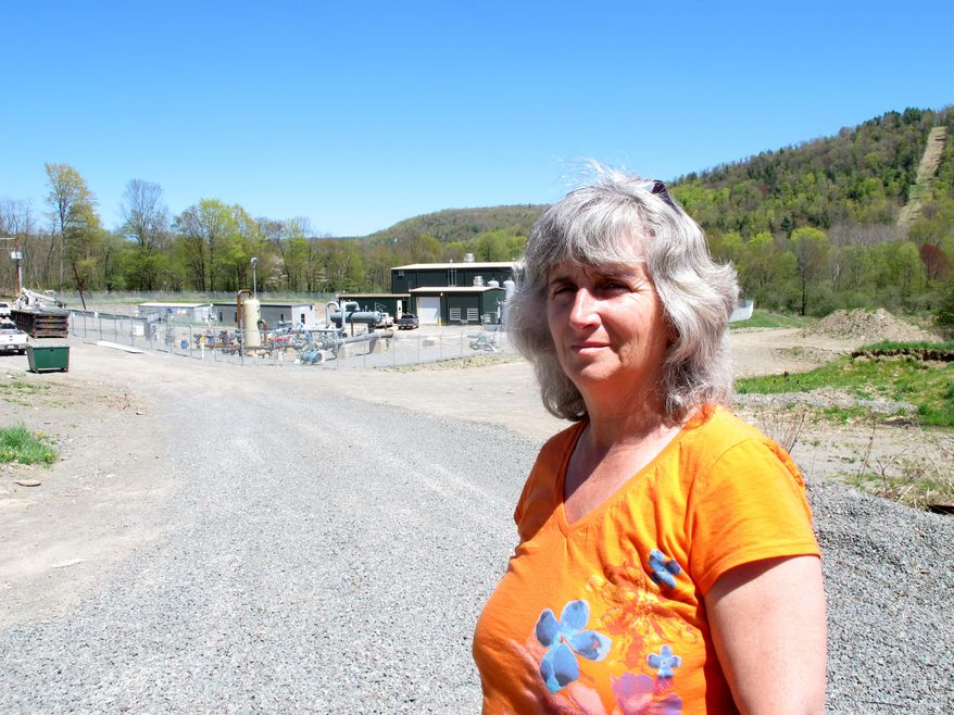 FILE - In this Monday, May 6, 2013, file photo, Vera Scroggins stands in front of a gas compressor station in Liberty Township in northwestern Pennsylvania. Scroggins, a high-profile anti-fracking activist who often gives tours of natural gas drilling sites in northeastern Pennsylvania's Marcellus Shale region, asked a judge Monday, March 24, 2014, for relief from an order barring her from stepping foot on more than 300 square miles of land owned or leased by one of the state's leading natural gas drillers. Scroggins said the injunction, in place since October, has effectively prevented her from traveling to her favorite grocery store, eye doctor, hospital, restaurants, businesses and friends' homes because all of them have leased land to Cabot Oil & Gas Corp. (AP Photo/Mary Esch, File)