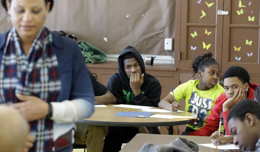 In this Feb. 27, 2014 photo, Detroit Police Officer Monica Evans, foreground left, holds a class that teaches anger management and conflict resolution skills at Cody High School in Detroit. A new Police Department program - the Children in Trauma Intervention Camp, offers the students an alternative to expulsion in the form of training and counseling from police officers and other adult mentors. (AP Photo/Carlos Osorio)