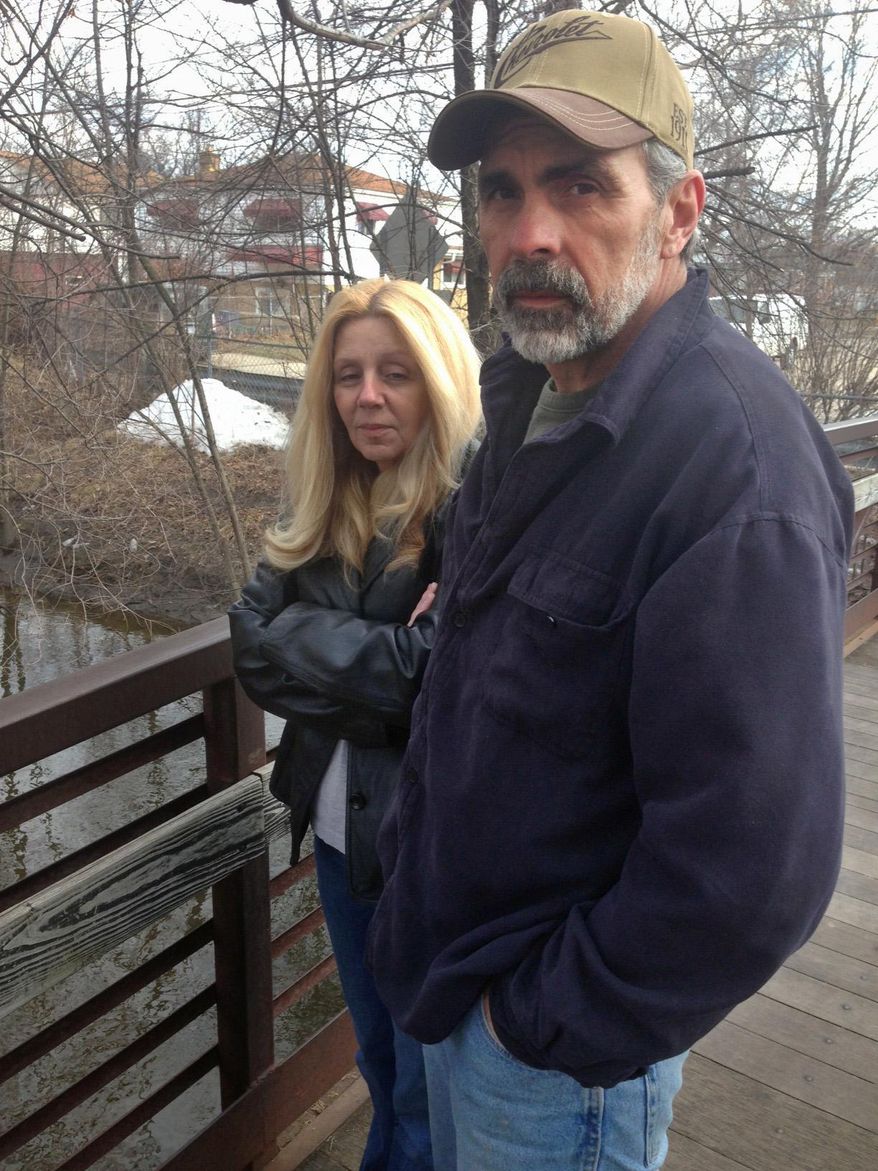 Katherine and Robert Calhoun stand on a bridge overlooking Ecorse Creek behind their Dearborn Heights, Mich., home on Thursday, March 20, 2014. Living so close to the creek in a flood plain has been costly — not the least because it's flooded twice and once caused $19,000 worth of damage they had to pay after their insurance claim was rejected. When the Calhouns bought the house 22 years ago, they paid $300 annually for flood insurance. That bill is now $800. It will only get worse for the Calhouns and people around the nation when federal flood insurance premiums go up soon as decades-old subsides through the National Flood Insurance Program start to end. (AP Photo/Corey Williams)