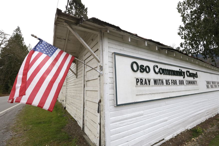 A flag flies from a small church off the highway leading to the scene of a deadly mudslide Monday morning, March 24, 2014, near Oso, Wash. Officials said that there are currently 108 names of people who have been reported missing or are unaccounted for from the Saturday morning slide, but cautioned the figure would likely decline dramatically. Eight people are so far confirmed dead from the one-square mile slide that destroyed about 30 homes and critically injured several people. (AP Photo/Elaine Thompson)