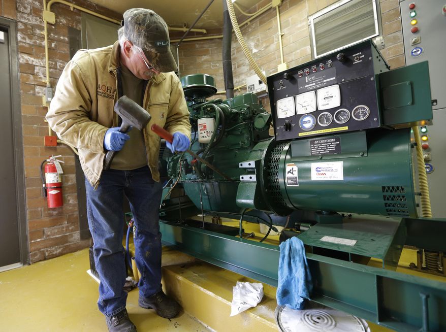 Jerry Fulbright, a maintenance worker for the city of Hoquiam, Wash., changes a gasket, Monday, March 18, 2014, on an electric generator that will power sewer and groundwater pumps in the event of a power failure. Most of Hoquiam is in a flood plain, and the mayor says despite the pumps and other measures used to reduce the town's risk of flooding, possible increases in federal flood insurance rates would adversely affect many who live here. (AP Photo/Ted S. Warren)