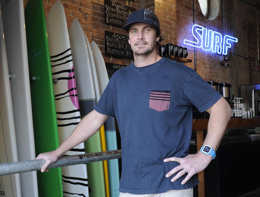 Damien McDonald stands in his Texas Surf Co. shop in Galveston, Texas on Thursday, March 20, 2014. McDonald nearly scrapped his plans to open a second surf shop in Galveston when he learned he'd have to pay more than $8,000 annually in flood insurance. President Barack Obama signed a law rolling back steep hikes that took effect almost overnight as a result of a 2012 law, but the legislation still imposes mandatory annual price increases of 25 percent on businesses and second homes until the owners switch from a subsidized rate to one based on the real risk of flooding. (AP Photo/Pat Sullivan)