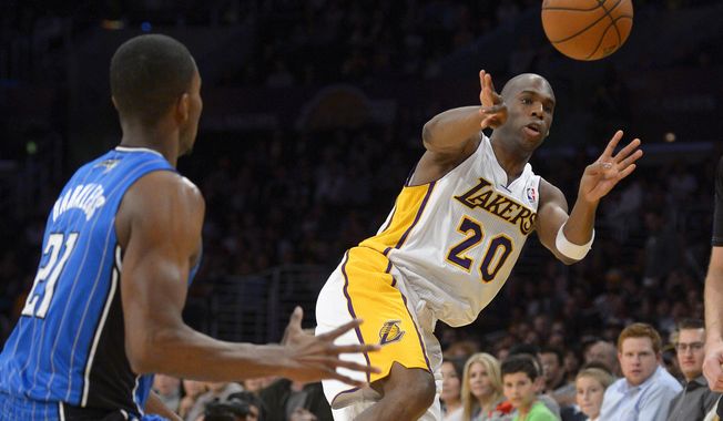 Los Angeles Lakers guard Jodie Meeks, left, passes the ball as Orlando Magic forward Maurice Harkless defends during the first half of an NBA basketball game, Sunday, March 23, 2014, in Los Angeles.  (AP Photo/Mark J. Terrill)
