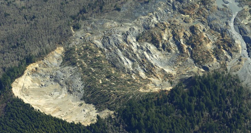 The massive mudslide that killed at least eight people and left dozens missing is shown in this aerial photo, Monday, March 24, 2014, near Arlington, Wash. The search for survivors grew Monday, raising fears that the death toll could climb far beyond the eight confirmed fatalities. (AP Photo/Ted S. Warren)