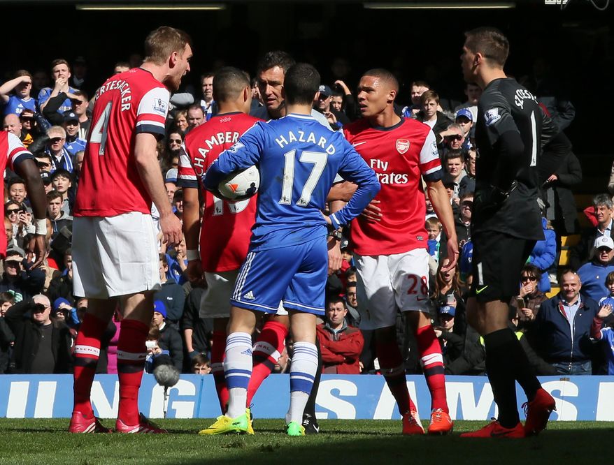 Arsenal's Kieran Gibbs, second right,along with teammate Alex Oxlade-Chamberlain, second left, question the referee Andre Marriner, in grey, after being shown a red card during their English Premier League soccer match between Chelsea and Arsenal at Stamford Bridge stadium in London Saturday, March 22 2014. Although Alex Oxlade-Chamberlain blatantly handled to keep out Eden Hazard's shot, it was Kieran Gibbs who was dismissed despite his teammate's protests. Hazard scored Chelsea's third from the resulting penalty.(AP Photo/Alastair Grant)