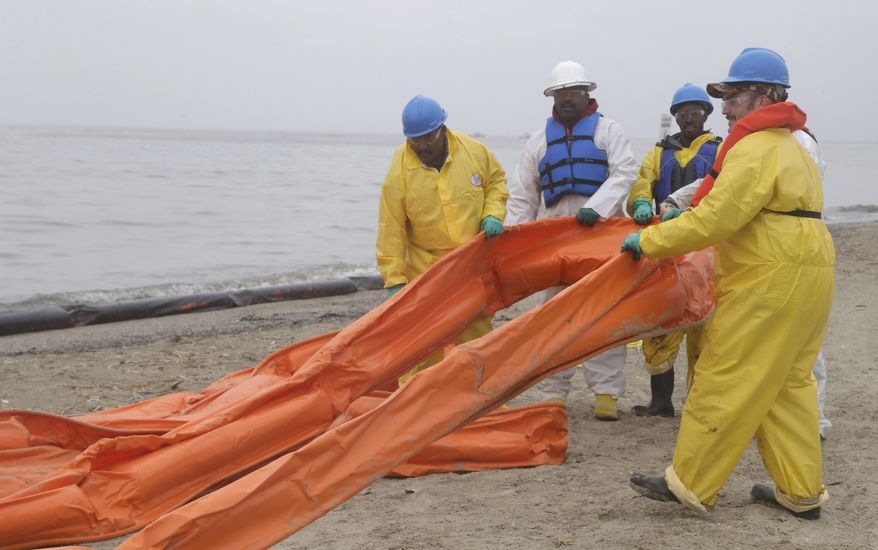 An oil spill clean up crew drags a boom along East Beach in Galveston, Texas, Monday, March 24, 2014. Thousands of gallons of tar-like oil spilled into the major U.S. shipping channel after a barge ran into a ship Saturday. (AP Photo/Pat Sullivan)