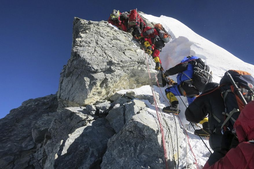 ** FILE ** In this image released by mountain guide Adrian Ballinger of Alpenglow Expeditions and taken Saturday, May 18, 2013, climbers navigate the Hillary Step just below the summit of Mount Everest, in the Khumbu region of the Nepal Himalayas. (AP Photo/Alpenglow Expeditions, Adrian Ballinger)