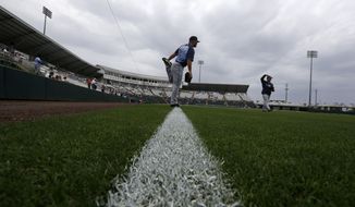 Tampa Bay Rays pitcher Adam Liberatore warms up on a tarp-covered field under the threat of a rain delay before an exhibition baseball game against the Minnesota Twins in Fort Myers, Fla., Monday, March 24, 2014. (AP Photo/Gerald Herbert)