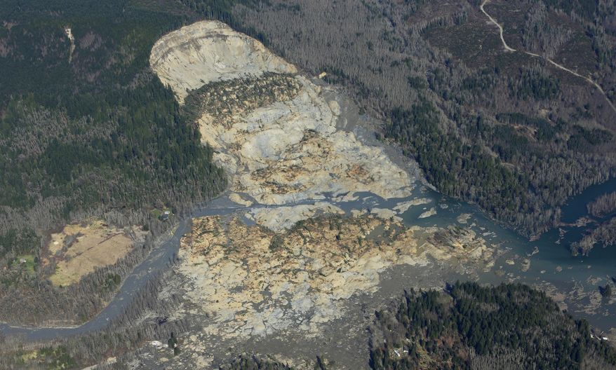The massive mudslide that killed at least eight people and left dozens missing is shown in this aerial photo, Monday, March 24, 2014, near Arlington, Wash. The search for survivors grew Monday, raising fears that the death toll could climb far beyond the eight confirmed fatalities. (AP Photo/Ted S. Warren)