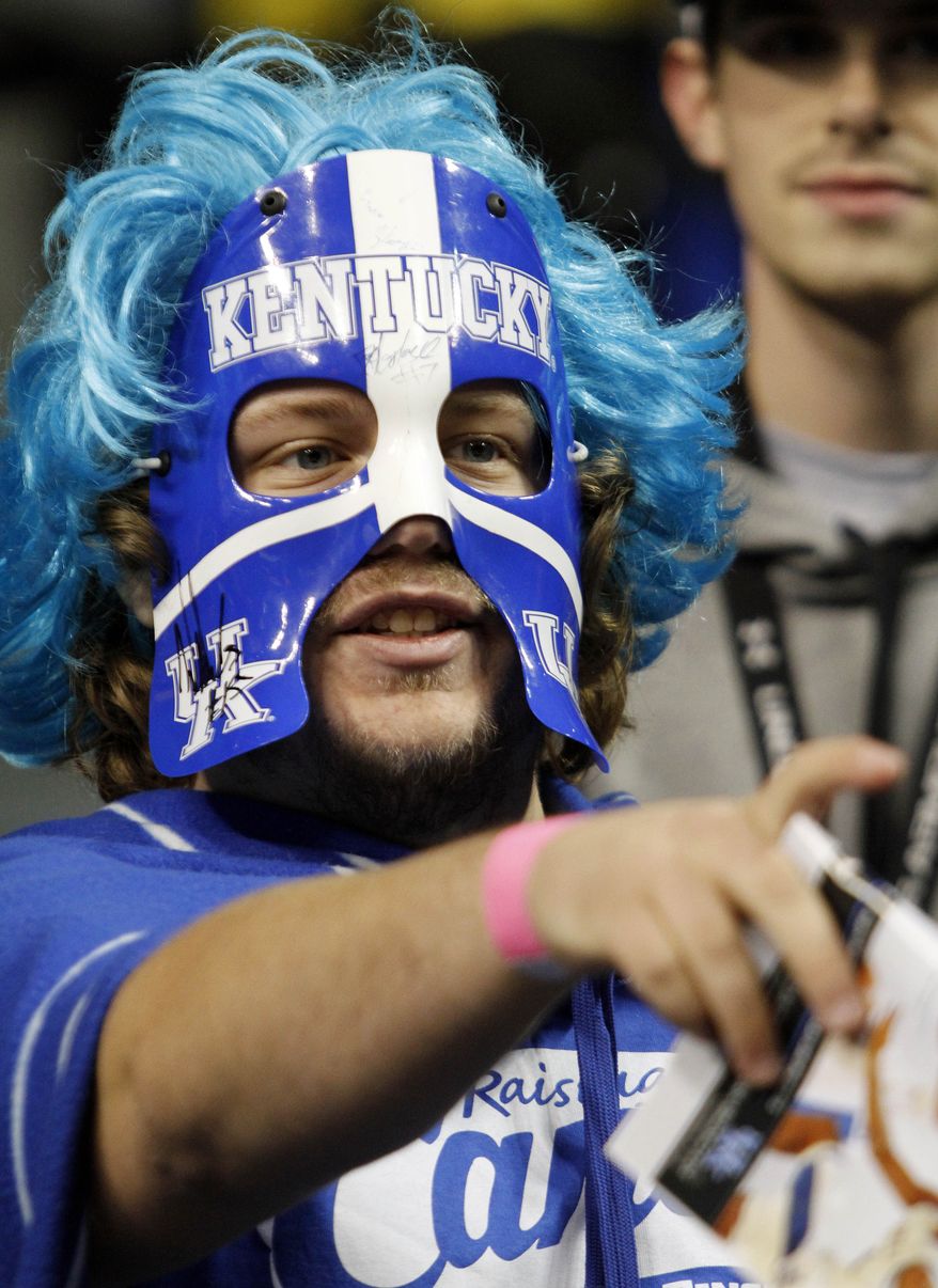 FILE - In this Nov. 19, 2013 file photo, Kentucky fan and student David Green gestures before an NCAA college basketball game between Kentucky and Texas-Arlington, in Lexington, Ky. Rivals Louisville and Kentucky will meet Friday, March 28, 2014, in Indianapolis, which will be invaded by a sea of fans clad in blue and red gear fans with the game just three hours away from both schools.(AP Photo/James Crisp, File)
