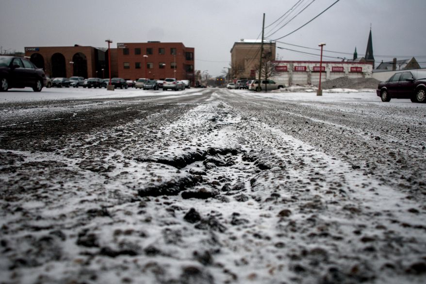 A light blanket of snow begins to cover the roadway, Tuesday, March 25, 2014, in Flint, Mich. Snow fell Tuesday in parts of the Lower Peninsula, including Grand Rapids and Detroit, and slippery roads led to Lansing- and Flint-area crashes. (AP Photo/The Flint Journal, Jake May) LOCAL TV OUT; LOCAL INTERNET OUT