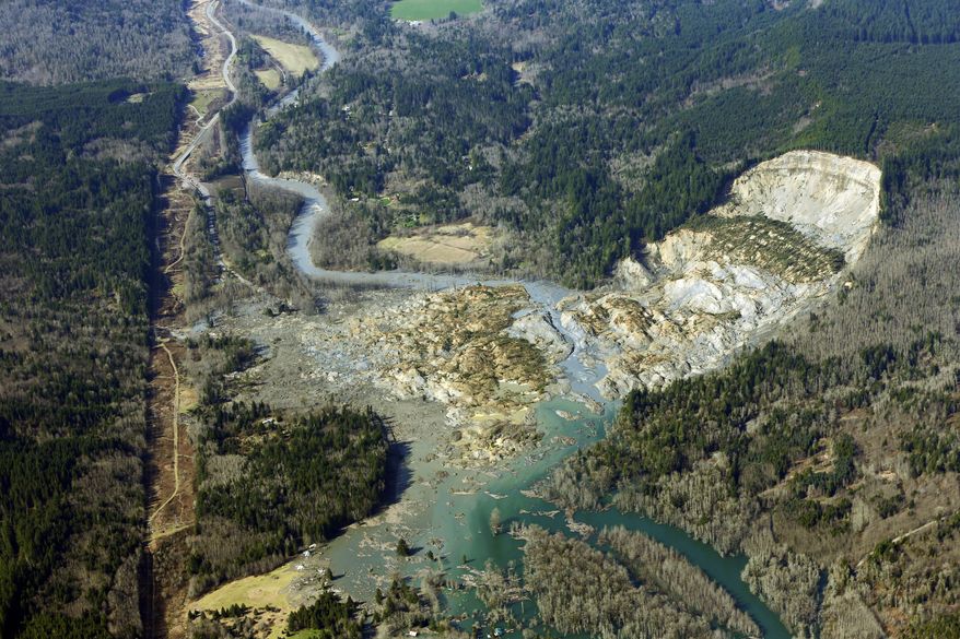 This aerial photo taken Monday, March 24, 2014 shows the massive mudslide that killed at least eight people Saturday and left dozens missing, near Arlington, Wash. The search for survivors grew Monday, raising fears that the death toll could climb far beyond the eight confirmed fatalities. (AP Photo/Ted S. Warren)