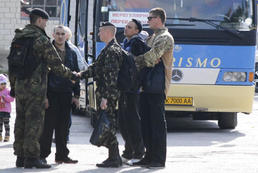Ukrainian marines prepare to leave their base in Feodosia, Crimea, Tuesday, March 25, 2014. In Crimea, Ukrainian soldiers piled onto buses and began their journey to Ukrainian territory on Tuesday, as former comrades saluted them from outside a base overrun by Russian forces. (AP Photo/Valeriy Kulyk)