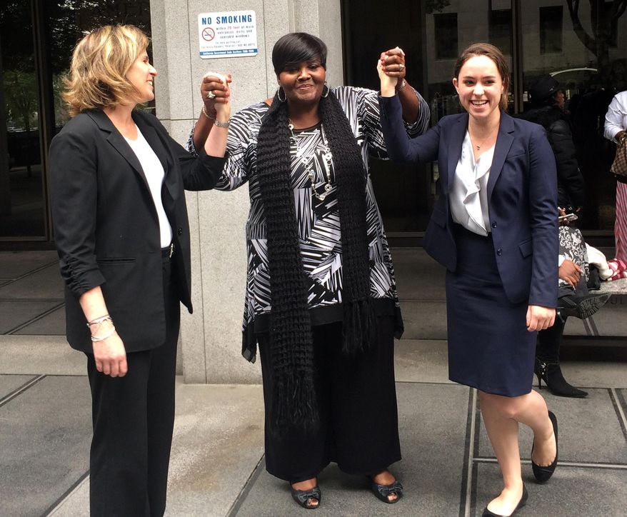 In this photo taken on Monday, March 24, 2014 and released by the University of Southern California Gould School of Law, USC Post-Conviction Justice Project attorneys, Heidi Rummel, left, and Laura Donaldson, right, celebrate with Mary Virginia Jones' daughter, Denitra Jones-Goodie, outside Superior court in Los Angeles. Mary Virginia Jones, a 74-year-old California woman, was freed late Monday after serving 32 years of a life sentence for her role in a 1981 killing. Los Angeles County prosecutors conducted a new investigation and agreed to accept a plea of no contest for involuntary manslaughter. Judge William C. Ryan ruled Monday afternoon that Jones had served well over the 11-year maximum sentence for the lesser crime and ordered her freed. (AP Photo/USC Gould School of Law, Jilien Silsby)