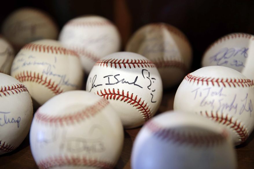 In this March 13, 2014 photo, a signed baseball with a self-portrait by rock musician Chris Isaak is shown in Dusty Baker&#x27;s collection at his home in Granite Bay, Calif. Out of uniform for the first time since taking 2007 off between managerial jobs with the Cubs and Reds, Baker is not slowing down much from his pressure-packed days in the dugout. (AP Photo/Eric Risberg)
