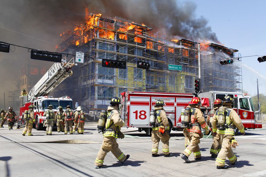 Houston firefighters work to extinguish a five-alarm fire at a construction site Tuesday, March 25, 2014, in Houston. Fire officials said more than 200 emergency personnel were at the scene Tuesday afternoon and were working to protect nearby buildings. (AP Photo/Houston Chronicle, Eric Kayne) MANDATORY CREDIT