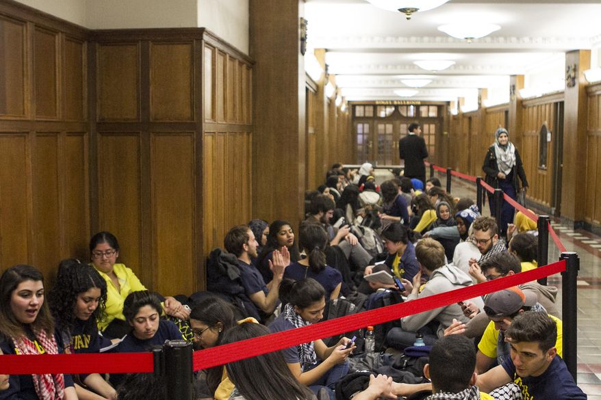Students stage a sit-in outside a University of Michigan student government meeting on a proposed anti-Israel boycott, Tuesday, March 25, 2014, in Ann Arbor, Mich. The proposal before the Central Student Government on Tuesday night was tabled without action last week, leading boycott supporters to stage a sit-in at the government's offices in the Michigan Union. (AP Photo/The Michigan Daily, Paul Sherman) LOCAL TV OUT; LOCAL INTERNET OUT