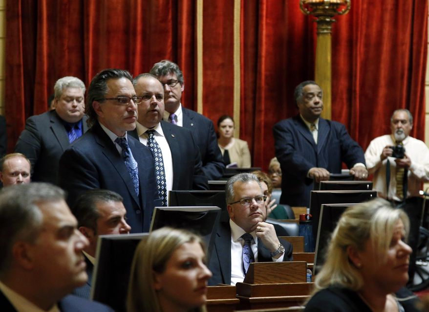 Democrat Nicholas Mattiello, of Cranston, R.I., sits at his seat (lower, middle) in the Rhode Island House of Representatives at the Statehouse in Providence, Tuesday, March 25, 2014 during the voting process for a new House Speaker.  Mattiello was elected after the abrupt resignation of Gordon Fox, one of the most powerful figures in state government, after his home and Statehouse office were raided as part of a criminal probe. (AP Photo/Elise Amendola)