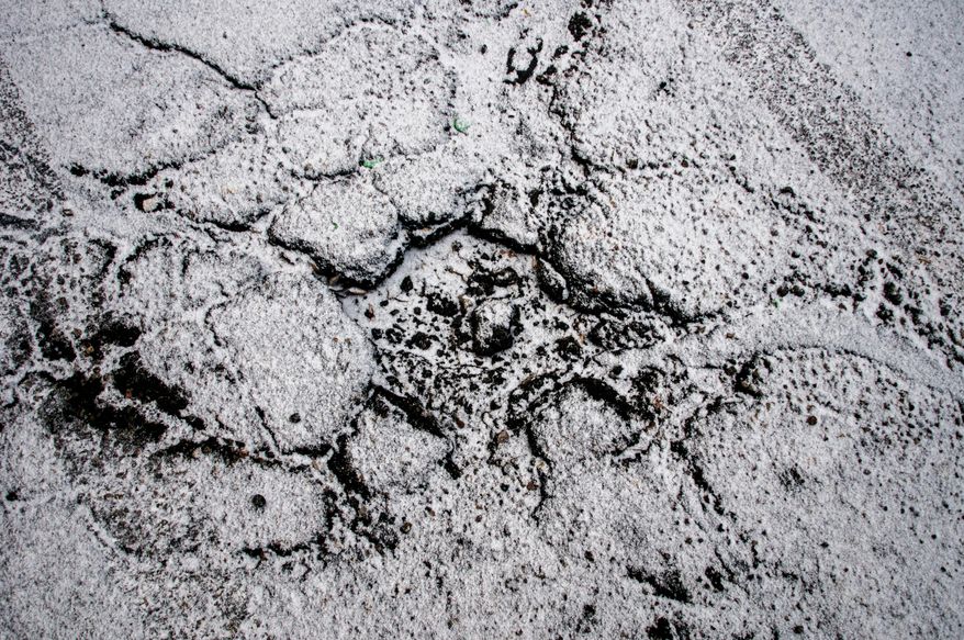 A light blanket of snow begins to cover the roadway, Tuesday, March 25, 2014, in Flint, Mich. Snow fell Tuesday in parts of the Lower Peninsula, including Grand Rapids and Detroit, and slippery roads led to Lansing- and Flint-area crashes. (AP Photo/The Flint Journal, Jake May) LOCAL TV OUT; LOCAL INTERNET OUT