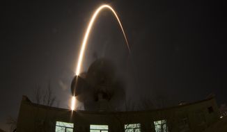 In this photo taken with a fisheye lens and long exposure, the Soyuz-FG rocket booster with Soyuz TMA-12M space ship carrying a new crew to the International Space Station (ISS) blasts off over an antenna at the Russian leased Baikonur cosmodrome, Kazakhstan, Wednesday, March 26, 2014. The Russian rocket carries U.S. astronaut Steven Swanson, Russian cosmonauts Alexander Skvortsov and Oleg Artemyev. (AP Photo/Dmitry Lovetsky)