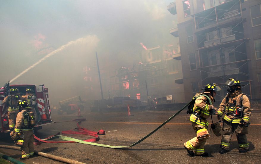 Houston firefighters work to extinguish a five-alarm fire at a construction site Tuesday, March 25, 2014, in Houston. Fire officials said more than 200 emergency personnel were at the scene Tuesday afternoon and were working to protect nearby buildings. (AP Photo/Houston Chronicle, Mayra Beltran) MANDATORY CREDIT: TV OUT
