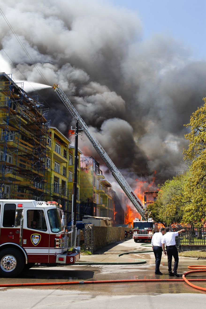 Houston firefighters work to extinguish a five-alarm fire at a construction site Tuesday, March 25, 2014, in Houston. Fire officials said more than 200 emergency personnel were at the scene Tuesday afternoon and were working to protect nearby buildings. (AP Photo/Houston Chronicle, Eric Kayne) MANDATORY CREDIT