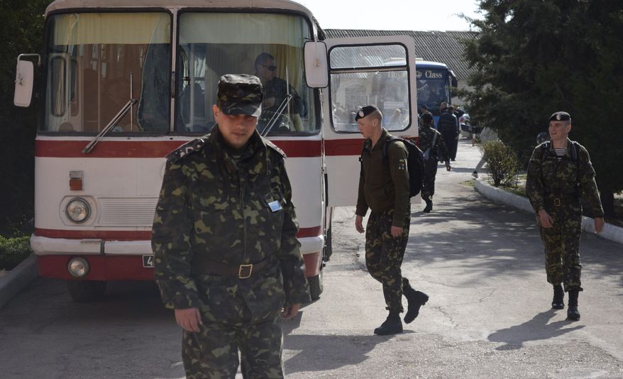 Ukrainian marines prepare to leave their base in Feodosia, Crimea, Tuesday, March 25, 2014. In Crimea, Ukrainian soldiers piled onto buses and began their journey to Ukrainian territory on Tuesday, as former comrades saluted them from outside a base overrun by Russian forces. (AP Photo/Valeriy Kulyk)