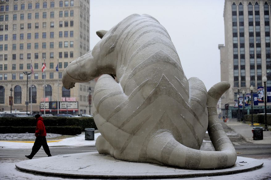 A person walks by a snow-covered tiger statue at Comerica Park, Tuesday, March 25, 2014, in Detroit. Up to an inch of snow is expected in the Detroit area on Tuesday. Detroit has seen its second-snowiest winter season on record, with 90.7 inches falling. The record is 93.6 inches set in 1880-1881. (AP Photo/Detroit News, David Coates) DETROIT FREE PRESS OUT; HUFFINGTON POST OUT; MANDATORY CREDIT