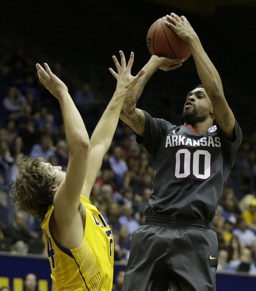 Arkansas guard Rashad Madden (00) shoots over California's Ricky Kreklow, left, in the first half of an NCAA college basketball game in the NIT tournament Monday, March 24, 2014, in Berkeley, Calif. (AP