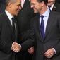 U.S. President Barack Obama, left, shakes hands with Dutch Prime Minister Mark Rutte, right, as they pose for a group photo on the last day of the Nuclear Security Summit (NSS) in The Hague, Netherlands, Tuesday, March 25, 2014. (AP Photo/Yves Logghe)