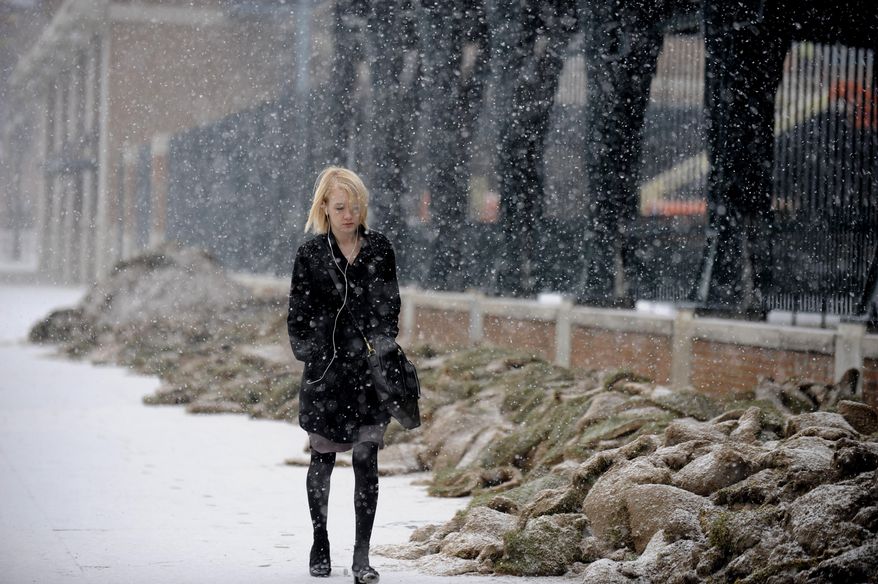 Michelle Matthews walks to work in the snow on Tuesday, March 25, 2014, in Detroit. Up to an inch of snow is expected in the Detroit area on Tuesday. Detroit has seen its second-snowiest winter season on record, with 90.7 inches falling. The record is 93.6 inches set in 1880-1881. (AP Photo/Detroit News, David Coates) DETROIT FREE PRESS OUT; HUFFINGTON POST OUT; MANDATORY CREDIT